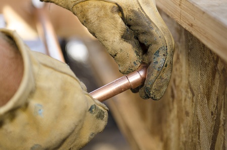 A Plumber Examines a Pipe Part Prior to Gas Line Repair or Installation