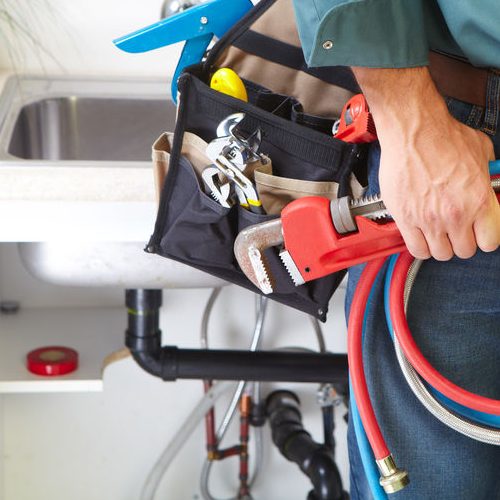 Close Up of Plumber With Tools in Front of a Kitchen Sink